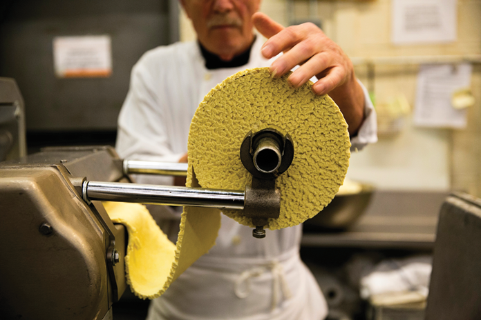 Pasta being freshly made with care. 