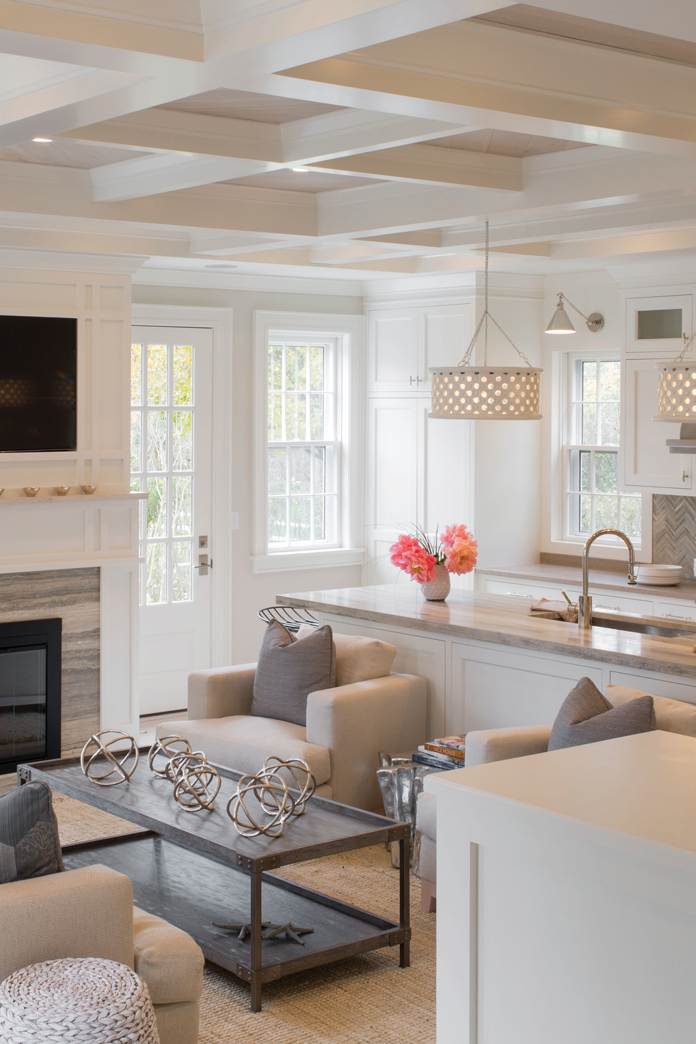 The Jared pendant lights by Arteriors that hang above the kitchen island were provided by  the Nantucket Lightshop. The coffee table  and dining chairs are  by Palecek.