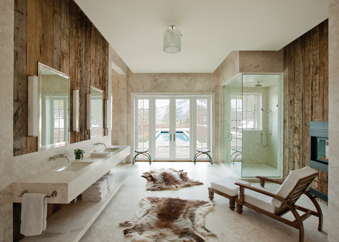 The master bath includes reindeer hide rugs by Pologeorgis Furs, a teak chair and ottoman covered in Ralph Lauren white terrycloth and contemporary sconces by Jean Perzel.