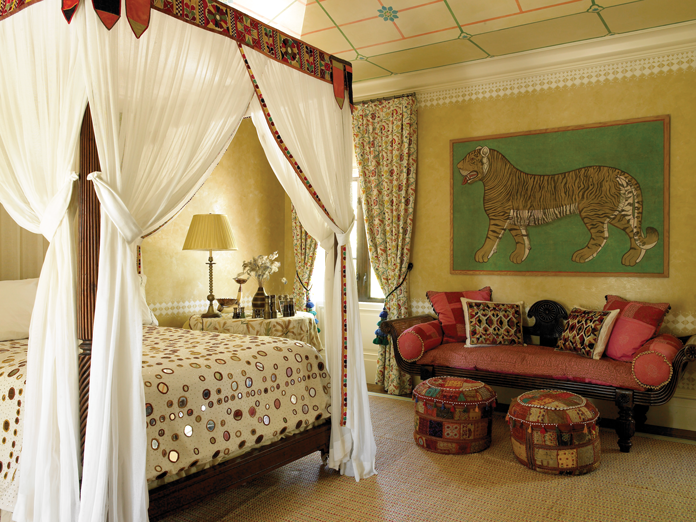 (right) This Palm Beach bedroom is an exotic getaway with mirror mosaic bedding by Shyam Ahuja, Moroccan poufs by Jalan Jalan and drapery fabric by Le Manach. The Indian tiger painting is from Galerie Blanchetti in France. (left) The breakfast room is grounded by a vintage green stripe carpet from Marrakech.