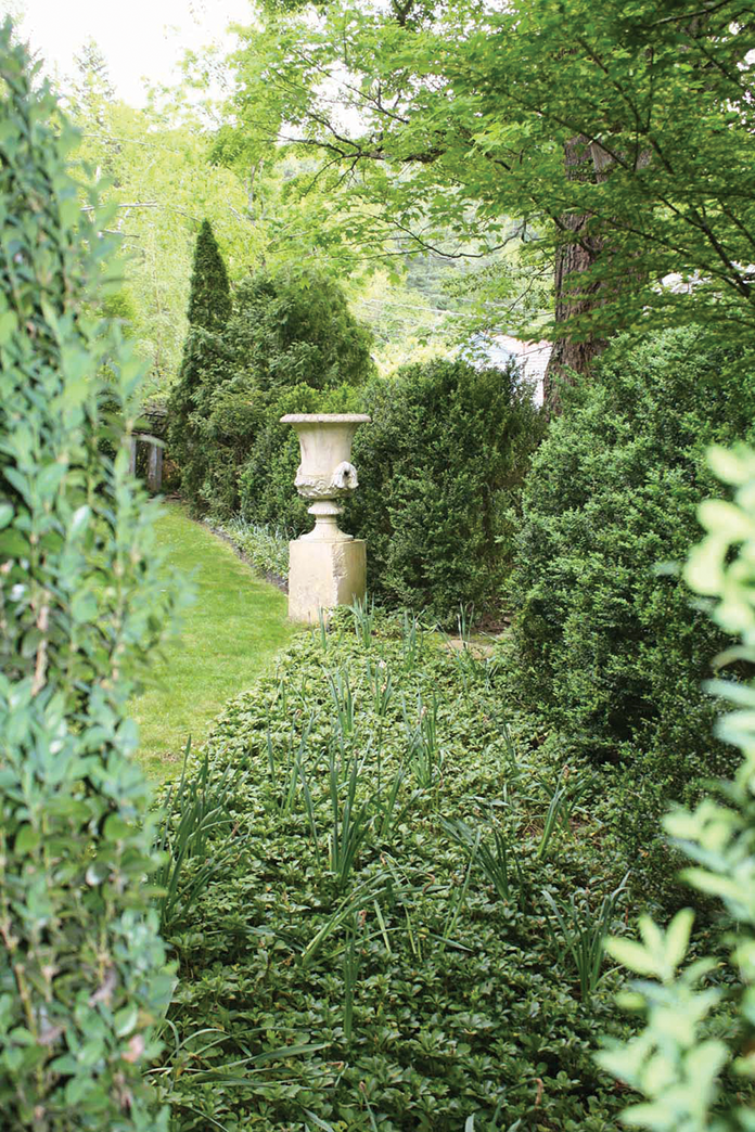 A corner of Trapp’s garden has boxwood hedges and a 19th century Neoclassical stone urn on a French limestone base.