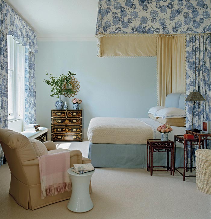 Blue and white  patterned cotton animate the  bedhangings and curtains of this charming bedroom. Photo by Simon Upton.