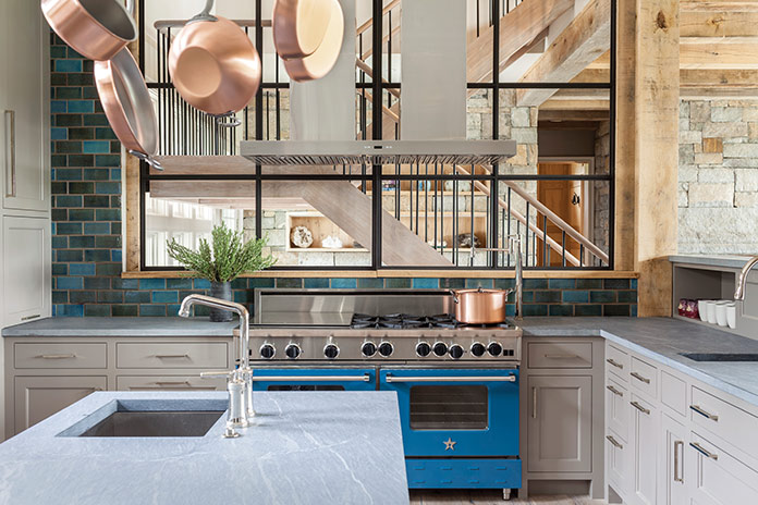Kitchen stove in blue with copper pots hanging above