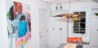 A clear kitchen table with modern artwork hung on the wall