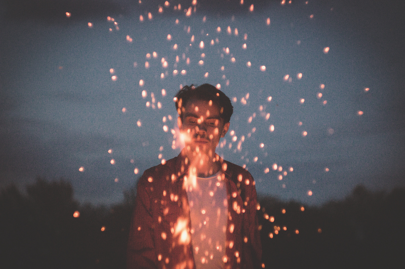 Boy with sparks of fire at night
