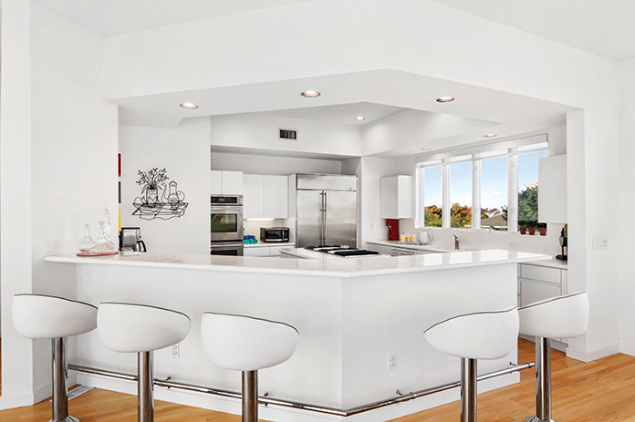 A white kitchen with bar stools