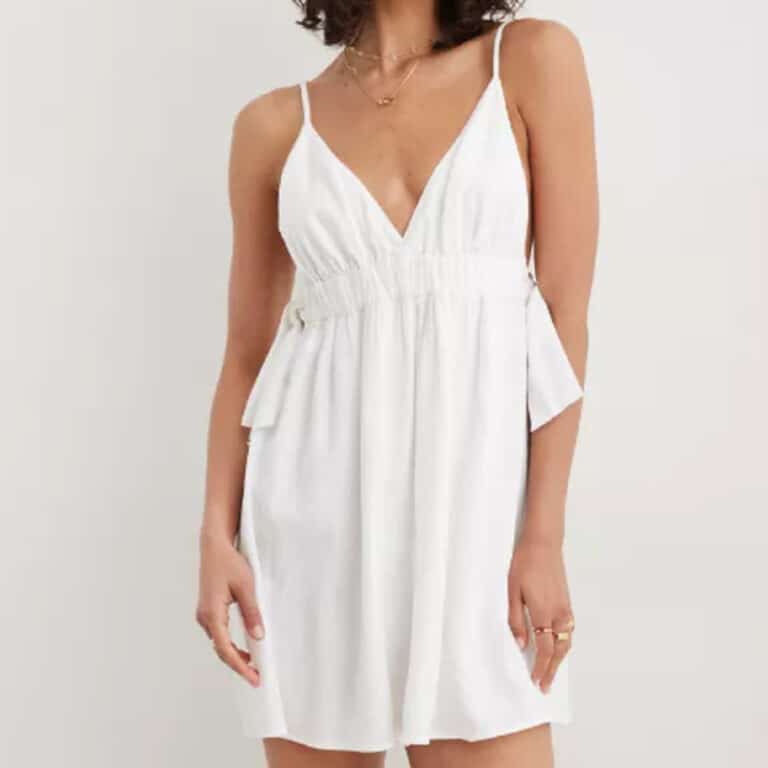 Mini white dress with side ties and thin straps on woman